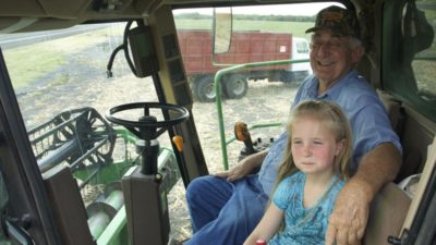 Sonny Bancroft and granddaughter in combine cab