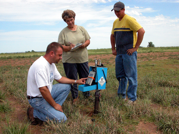 Three people in field during hands-on  activity during the BattleGround to Breaking Ground program.  