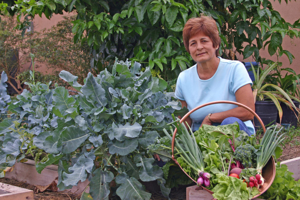 Woman in backyard garden with homegrown produce
