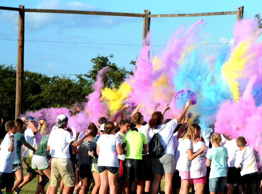 A bunch of people with their backs to the camera look on as colorful spray fills the air during an event at the state 4-H center at Brownwood.