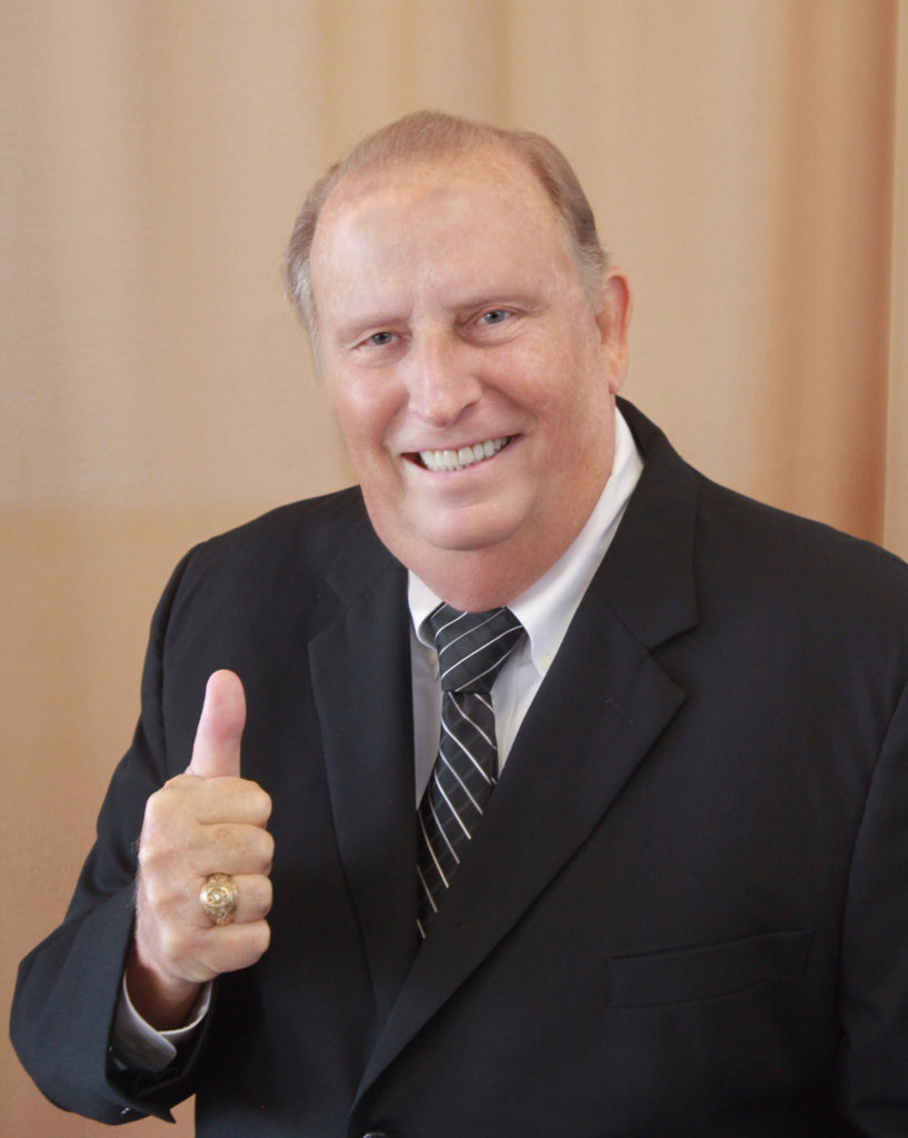 A man in a suit and tie with his thumb up in the "gig-em" gesture - The late Joe Townsend, Ph.D. 