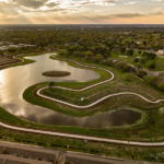 An aerial view of a pond with walking paths around it