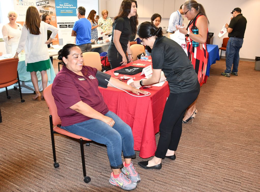 Woman getting blood pressure checked at health fair. 