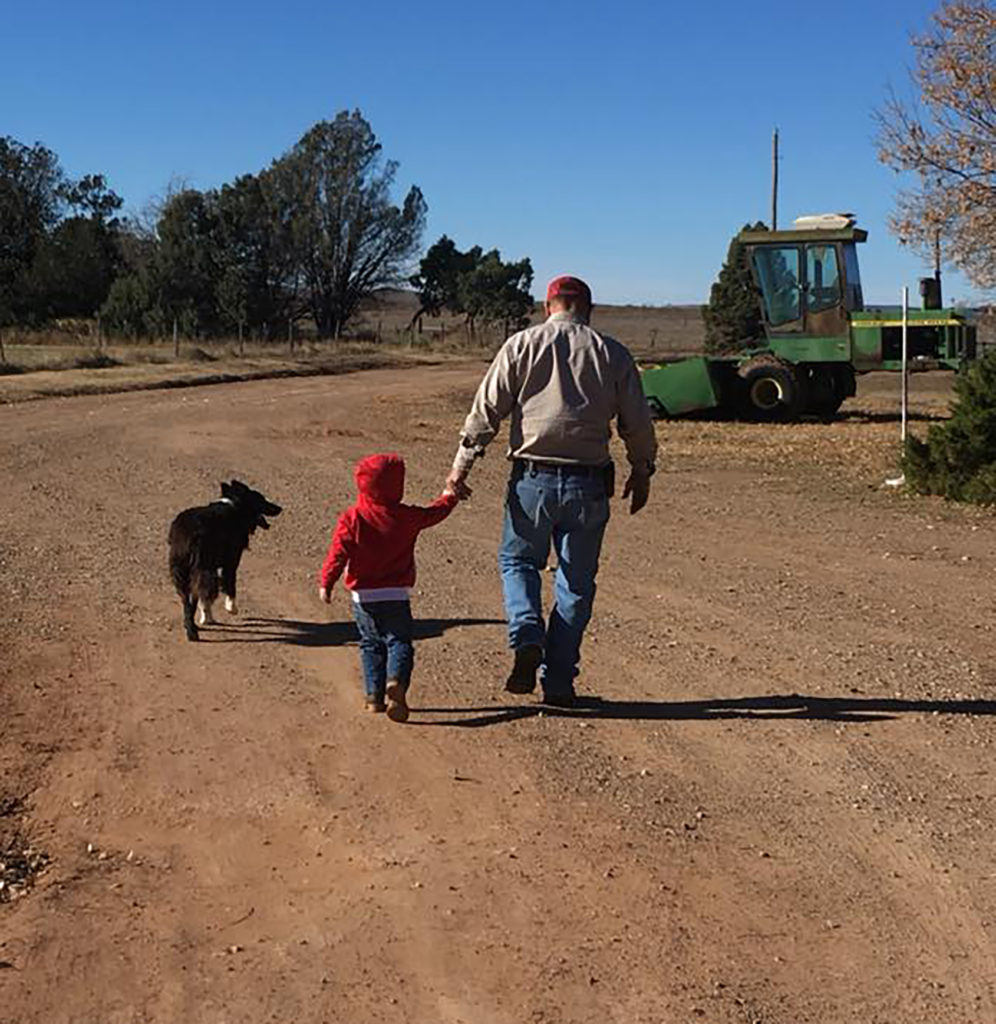 Farmer and grandson walking on farm 
