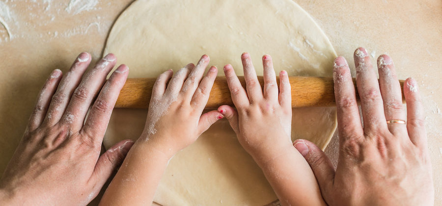 Hands rolling dough