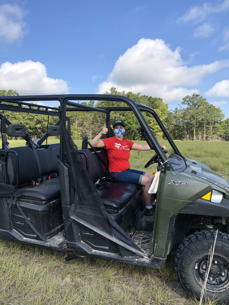 Woman driving ATV in Range Area bordered by trees
