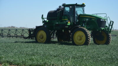 Close up of ground rig sparying pesticide on a wheat field