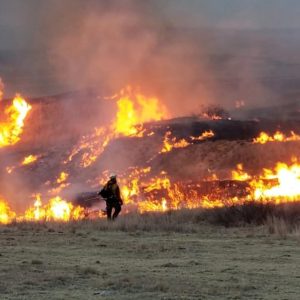 firefighter pictured in front of a rolling grassland fire - holiday safety is being called for