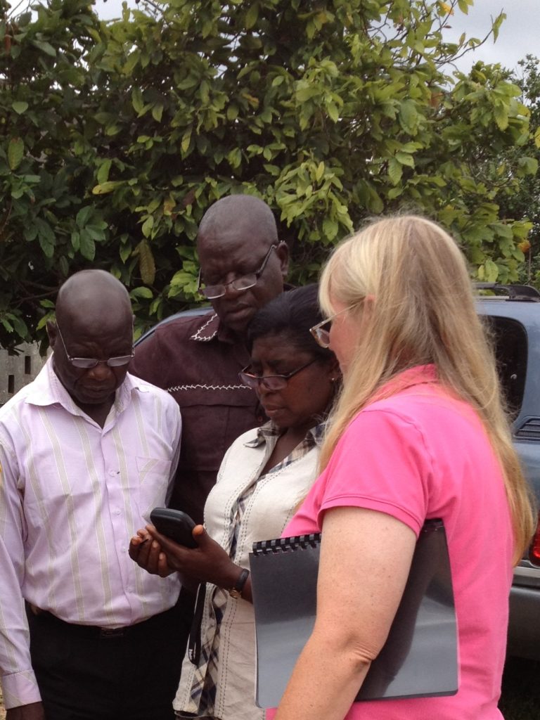 Jill Urban-Carr, Ph.D., showing people in Ghana how to use a handheld GPS device