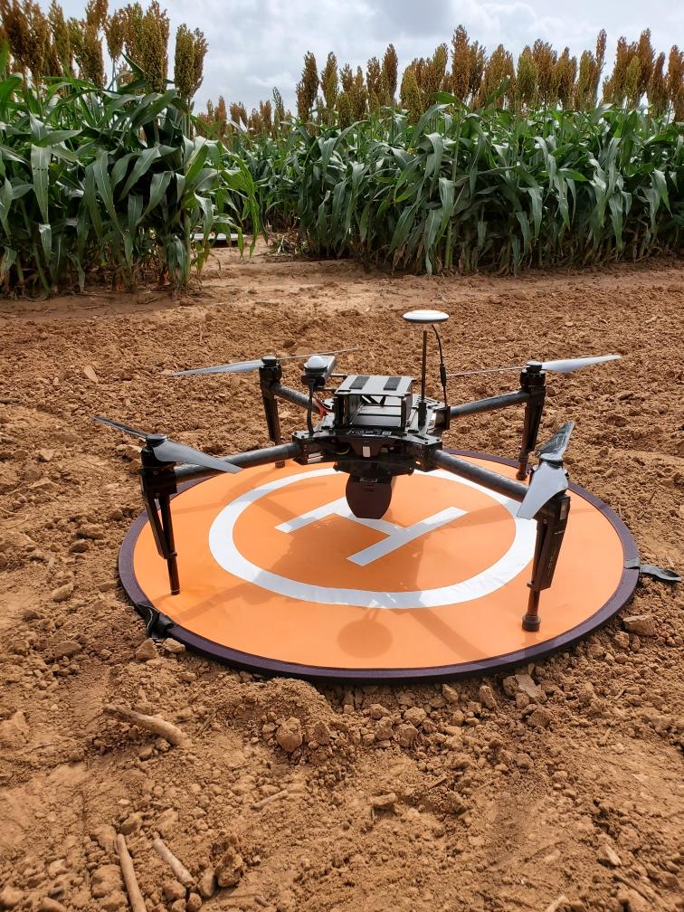 Drone on takeoff and landing pad in field