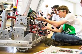 two boys, one wearing a 4-H t-shirt, work on a robot
















Texas 4-H member doing robotics activity


