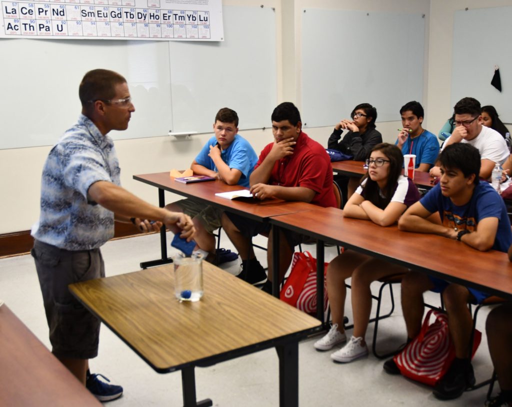 A teacher at the front of a group of Juntos 4-H students in a science class