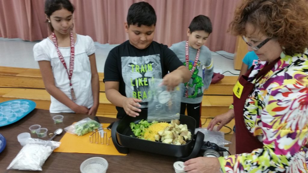 Kids learning to cook using vegetables they grew