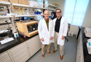 Two men in lab coats, Del Gatlin (left) and Jeff Tomberlin, in a lab setting.