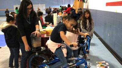 Raquel Rodrigues shows students how to mix smoothies with special bike