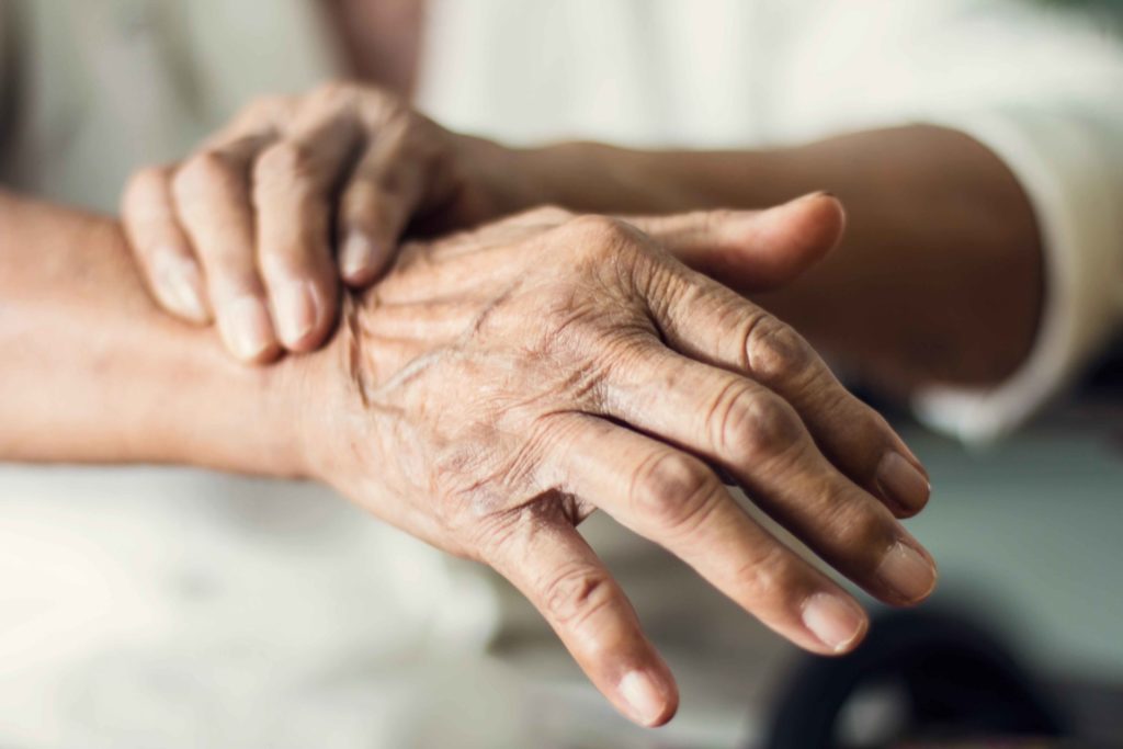Close-up of hands of a senior woman suffering from Parkinson's disease. 