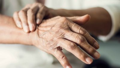 Close-up of hands of a senior woman suffering from Parkinson's disease.