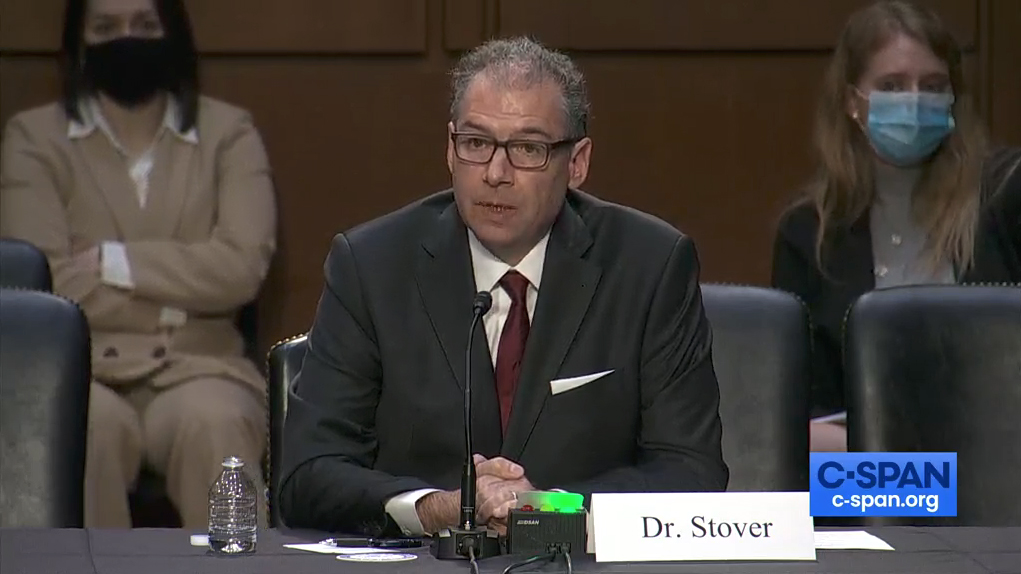 A man sits center screen and appears to be talking - he is testifying on agriculture's role in health - while two masked women sit behind him. There is a small C-Span logo in the lower left hand corner.