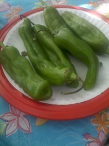 five green chiles on a plate