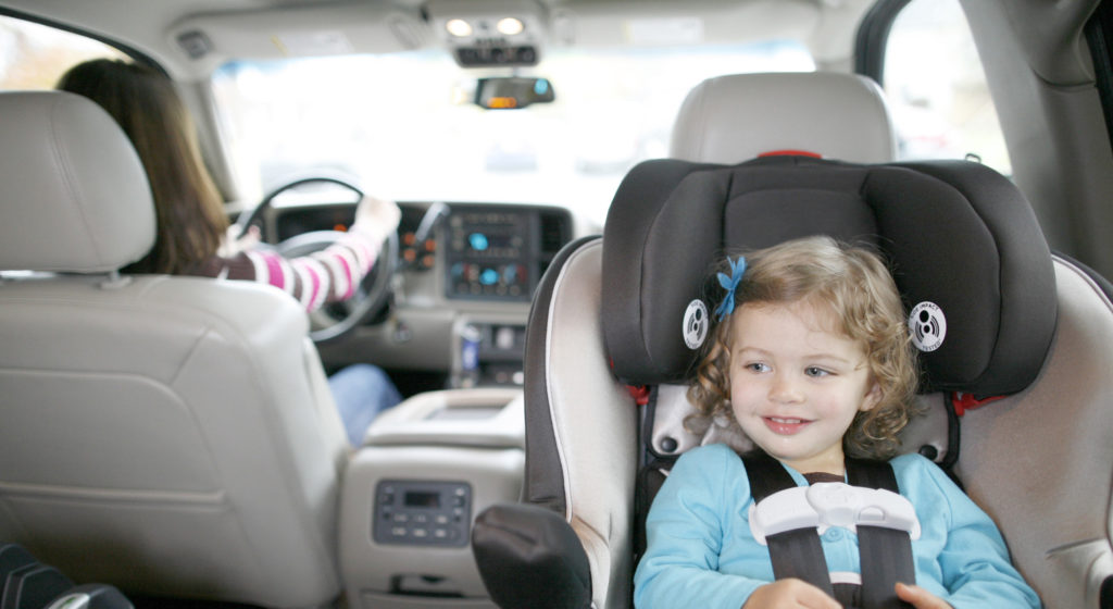 Young girl secured in child safety seat