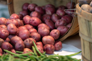 Red potatoes spilling from a wooden basket