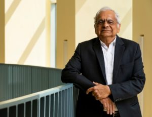 A man, Girish Agarwal, Ph.D., poses alongside a railing. He was named the 2022 Charles Hard Townes Medal winner. 