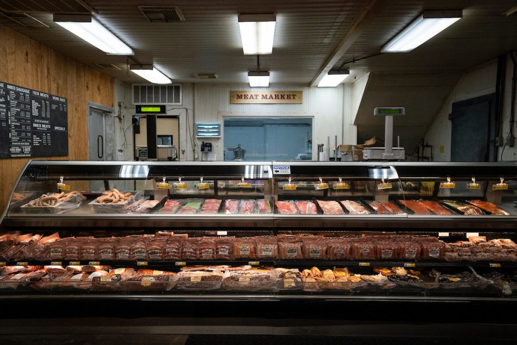 A meat market counter with various cuts of meat. 