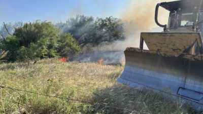 Brush pile on fire with dozer in front