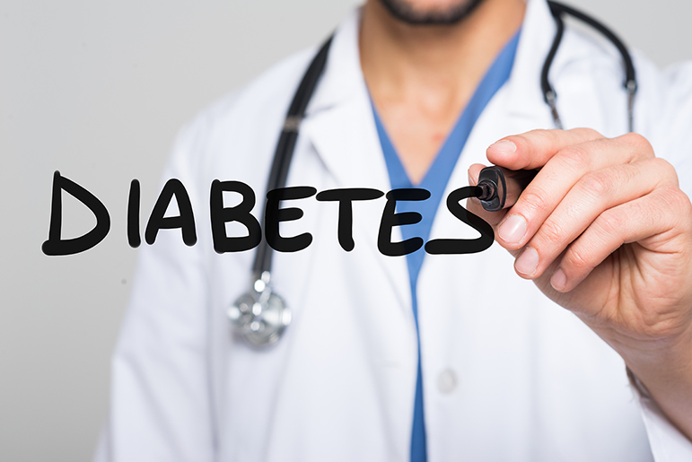 A doctor in a white coat with stethoscope writes the word Diabetes on a clear board facing the camera. The stock image is for the Do Well, Be Well with Diabetes program.