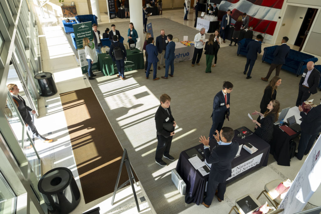 Attendees walking around on the floor visiting booths at the Financial Planning Career Fair.