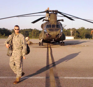 Buster Robinson, veteran and Texas A&M Forest Service Incident Aviation Operations Officer, stands near helicopter.