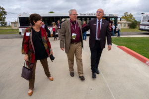 A woman and two men, members of the College of Agriculture Development Council, walk down the sidewalk on the RELLIS campus