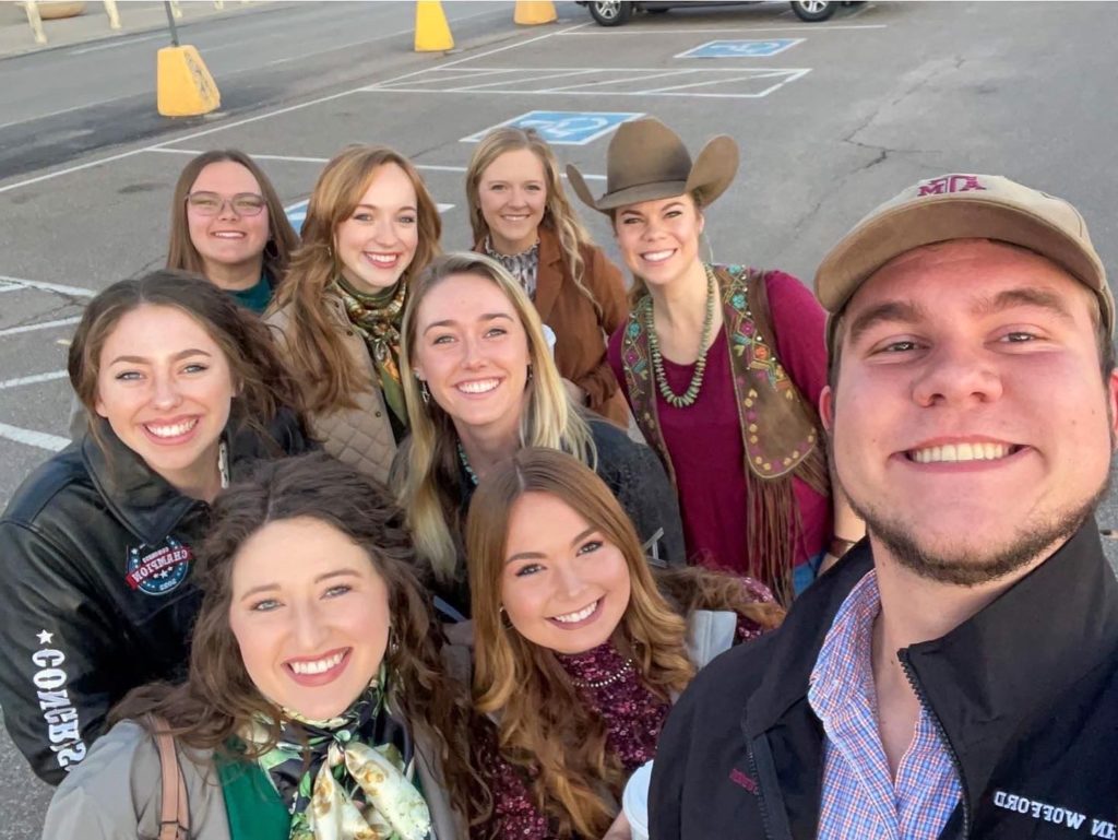 Nine smiling faces of the Texas A&M Horse Judging Team in a group photo