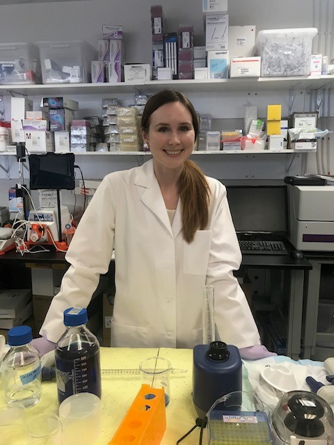 Lauren Cornell, Ph.D. in white lab coat standing in laboratory at NovoThelium