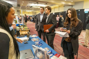 Three students visit with recruiters at a booth at the AGLS Career Fair.