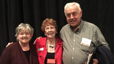 Two women and one man pose together at a Texas Master Gardener event.