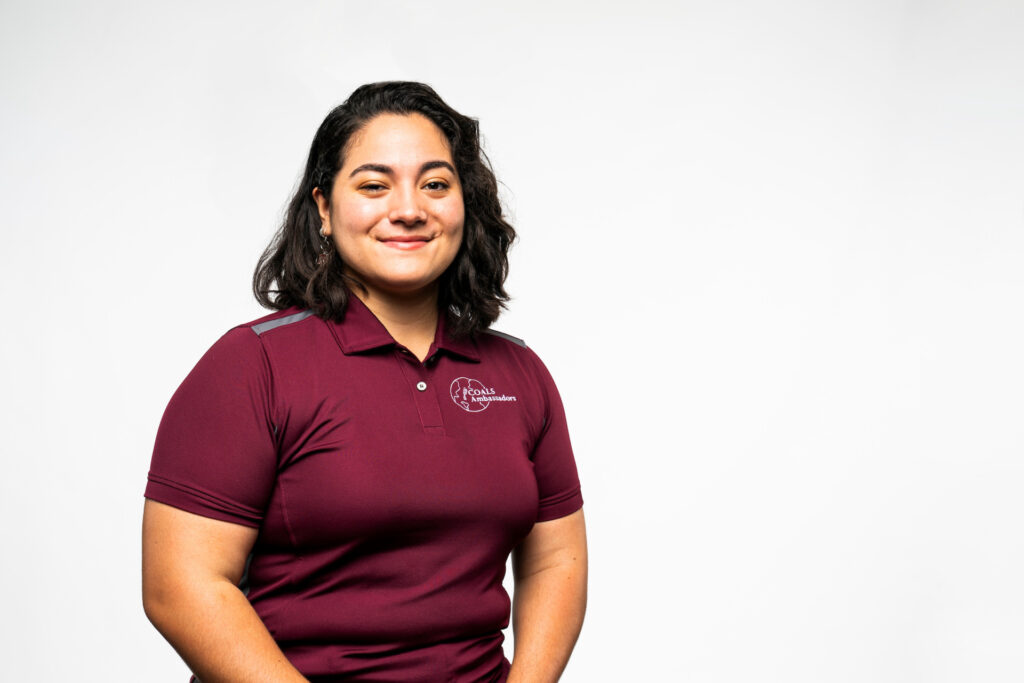 a smiling student, Grace Bodine, in a maroon shirt
