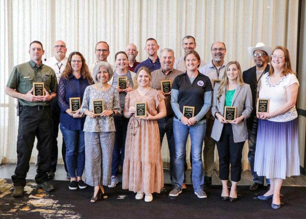A group of people standing with plaques in their hands after graduating from the Texas A&M Forest Service Leadership Institute