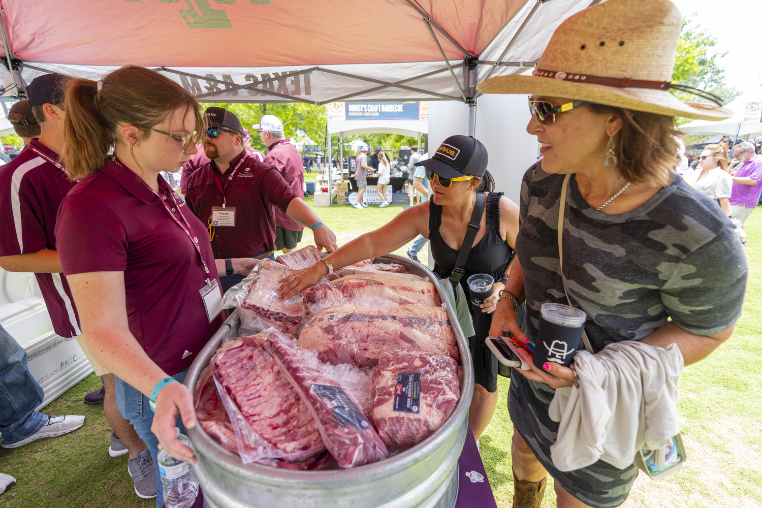 Students explaining different cuts of meat for barbecue to guests during the Troubadour Festival