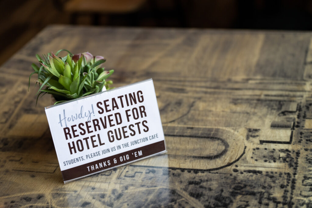 A small sign on a coffee table: "Howdy! Seating reserved for hotel guests only"