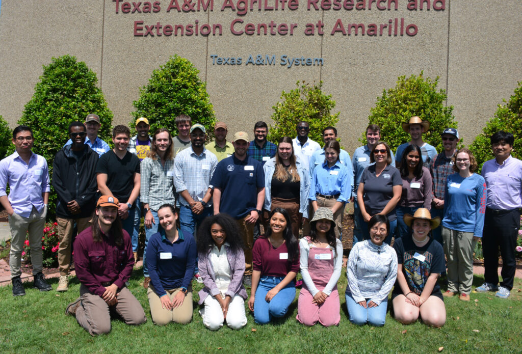 una foto grupal de unas 30 personas de pie frente al Centro de Investigación y Extensión AgriLife de Texas A&M en el edificio Amarillo.
