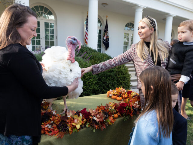 Leslee Oden sostiene un gran pavo blanco mientras Ivanka Trump lo acaricia mientras sostiene a un niño y dos niños observan.