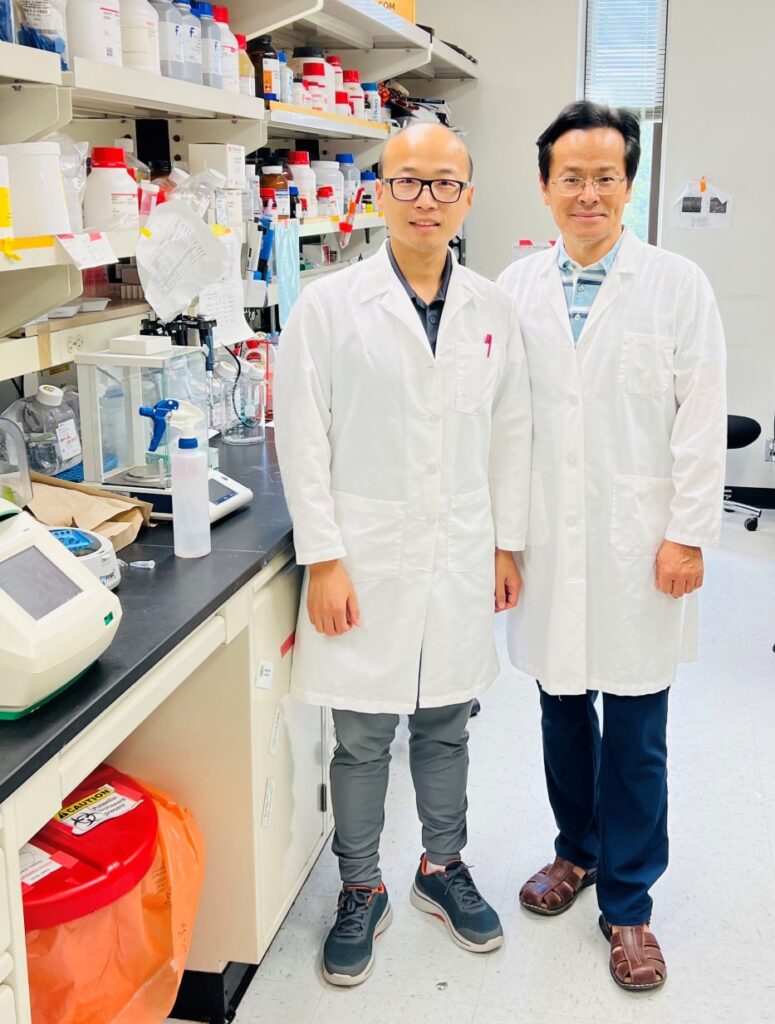 Wanbao Yang, Ph.D. (left) and Shaodong Guo, Ph.D., first author and PI on the diabetes study, standing side by side in lab and wearing white lab coats