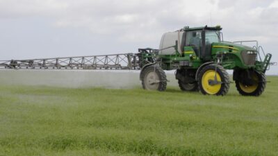 A spray rig sprays pesticide on a farm.