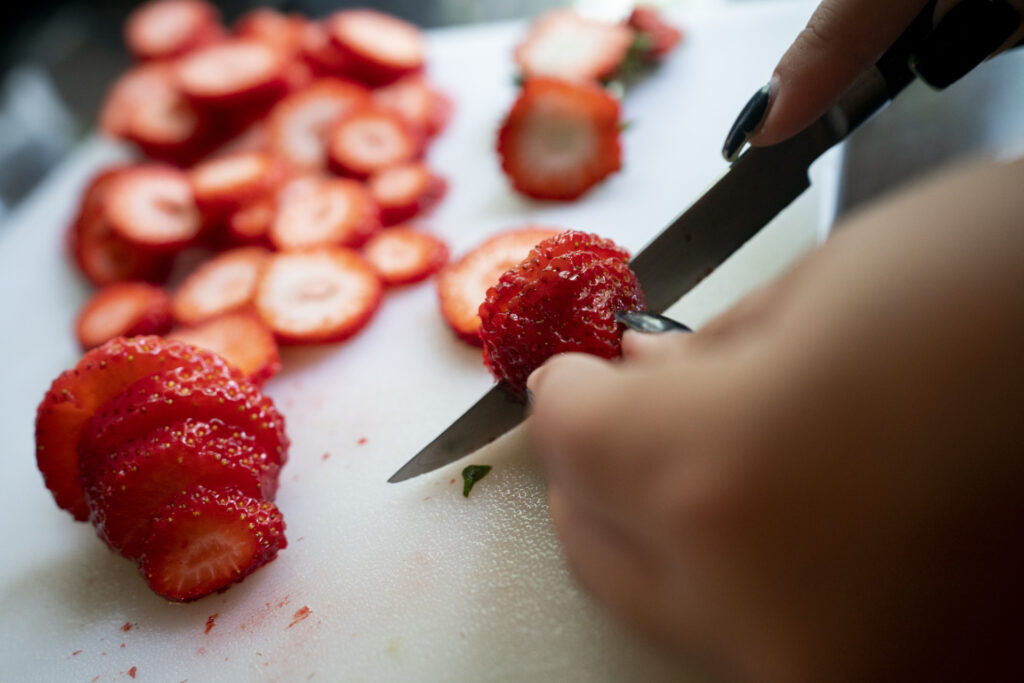 Up close photo of strawberries being cut