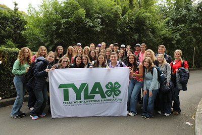 TYLA ambassadors in Australia holding a white flag with green TYLA lettering in a group photo. 