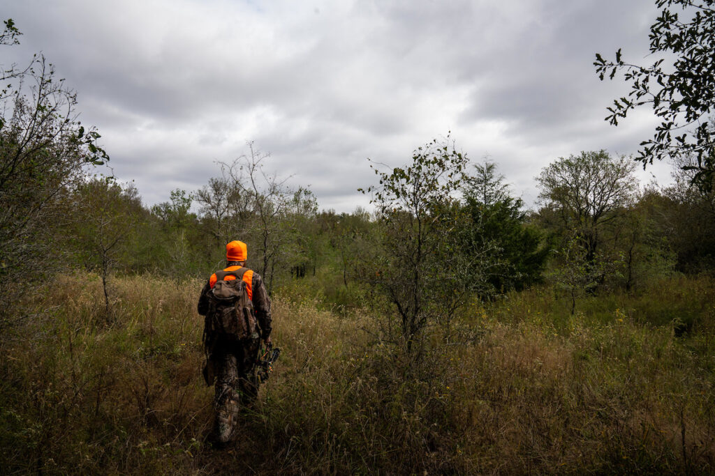 An image of a hunter walking through the outdoors. 