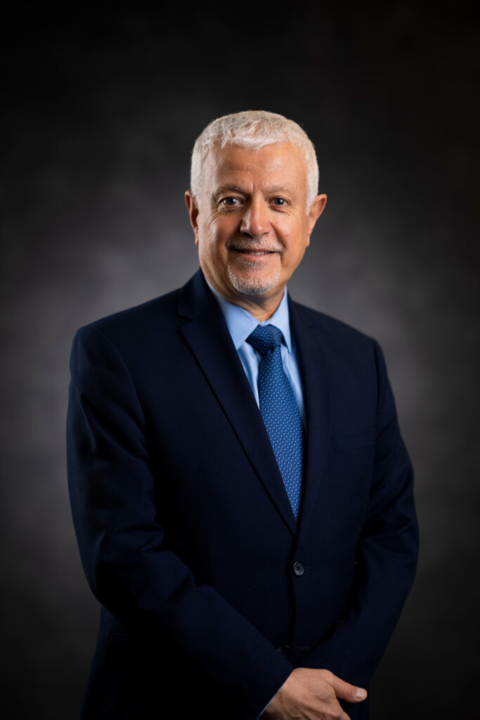 Head and shoulder shot of Rabi Mohtar, Ph.D. He is wearing a dark blue blazer with a light blue short and blue tie. 