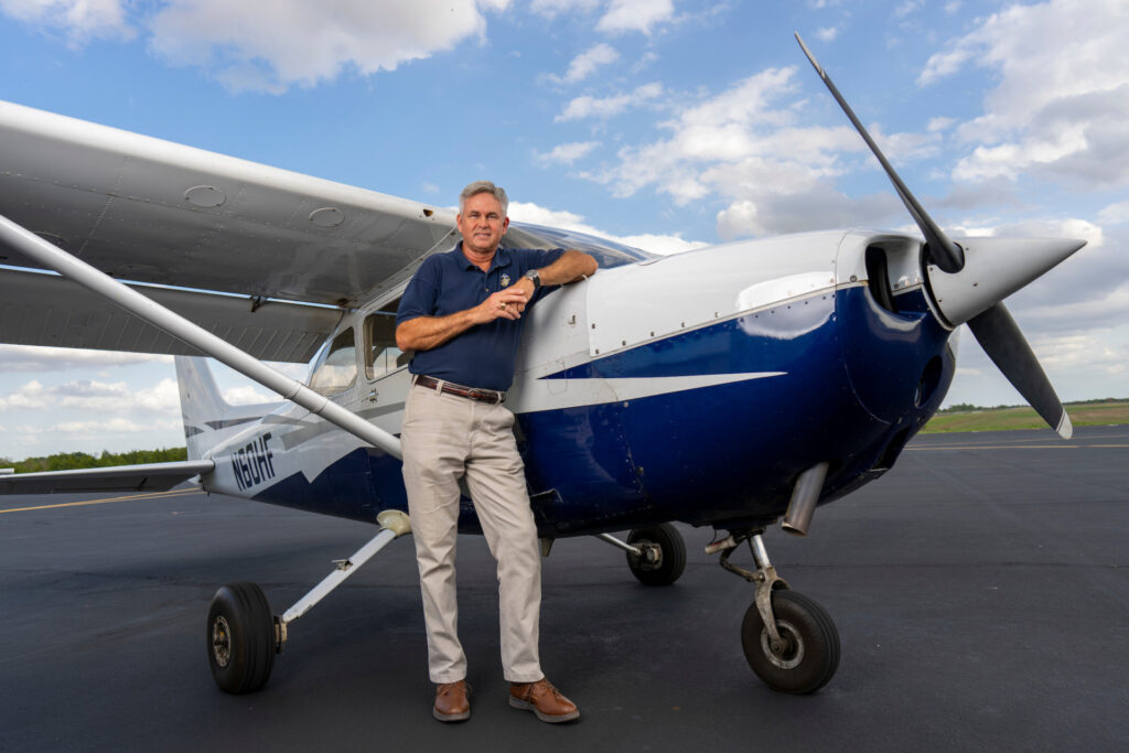 Russell McGee, whose career includes being a commercial pilot and flight instructor, standing by Cessna airplane.