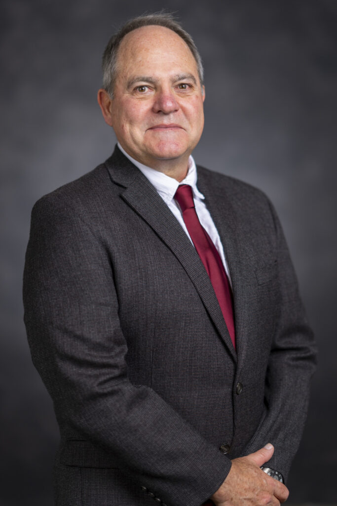 Profile photo of a man, Gary Wingenbach, Ph.D. He is wearing a dark suit with a white shirt and a maroon tie. 